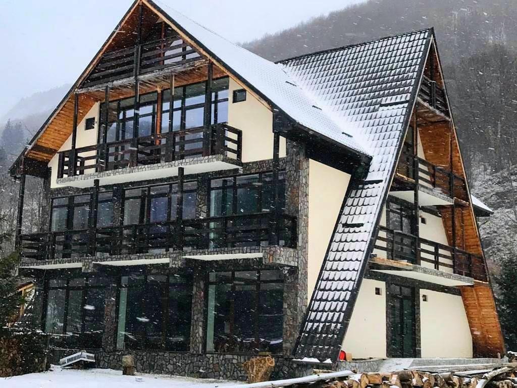 a house in the snow with at Cabana Riverdale in Podu Dîmboviţei