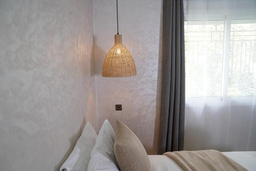 1 dormitorio con luz colgante y 1 cama en Hidden Haven, en Chefchaouen