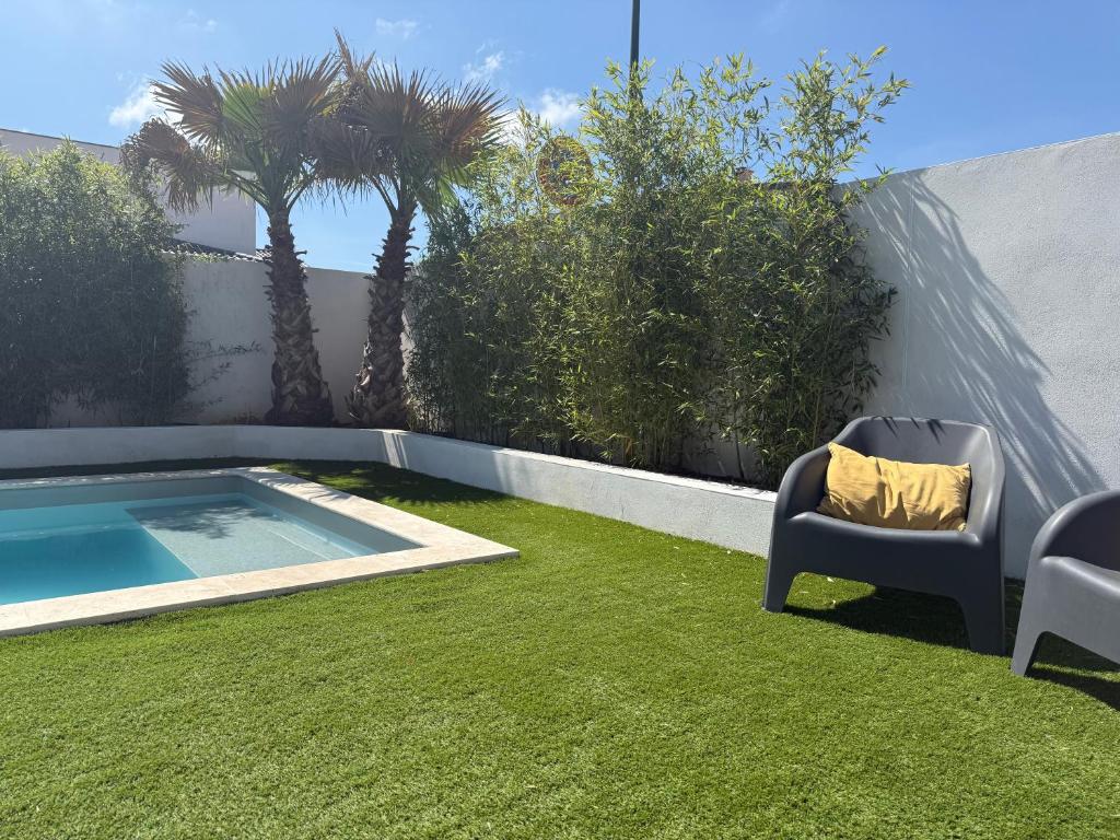 un jardin avec une chaise et une piscine dans l'établissement Villa Palma, à Lignan-sur-Orb