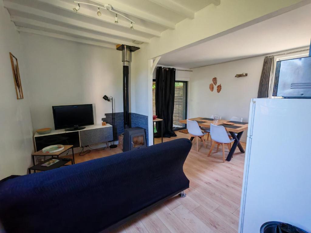 ein Wohnzimmer mit Sofa und Tisch in der Unterkunft Gîte Nature sur LAC avec accès PISCINE et PONTON in Éguzon-Chantôme