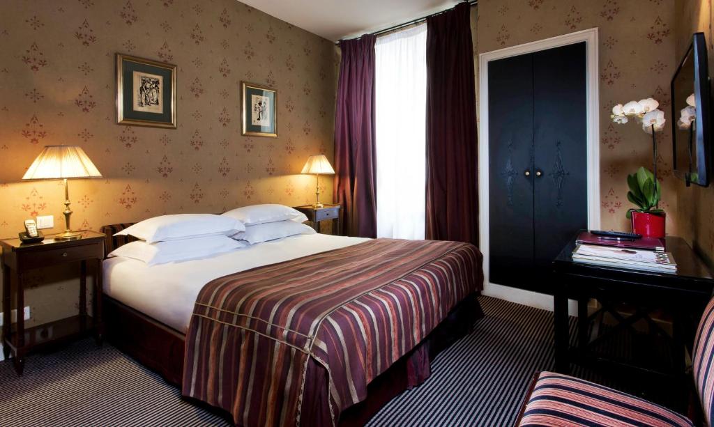 a hotel room with a large bed and a window at Hotel Residence Des Arts in Paris