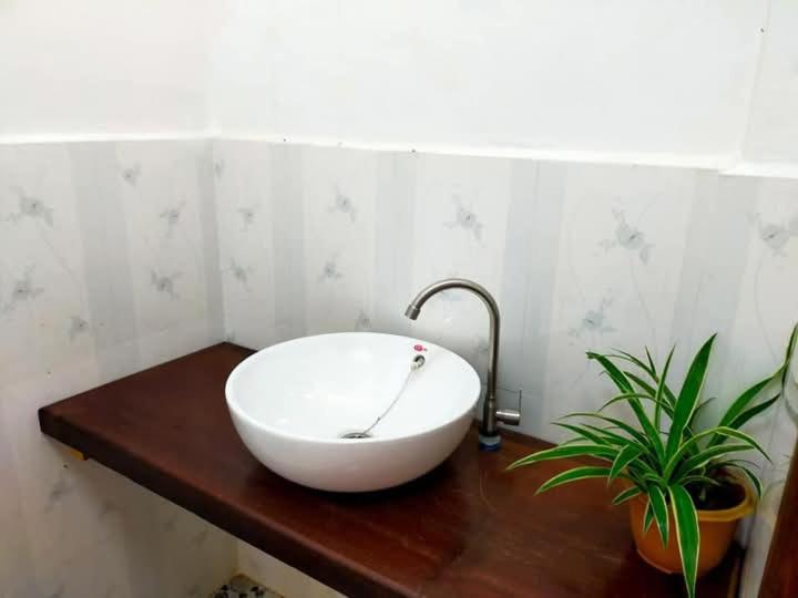 a white bowl sink on a wooden counter in a bathroom at Cam u view Guest House in Nongkhiaw