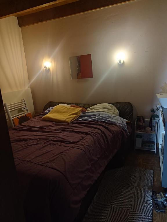 - un lit dans une chambre avec deux lumières sur le mur dans l'établissement Maison d ôte, à La Celle-sous-Gouzon