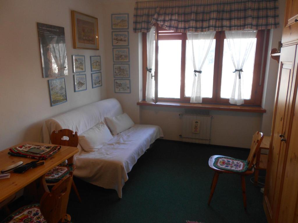 salon z kanapą, stołem i oknem w obiekcie Monolocale Milky Way - Sestriere w mieście Sestriere