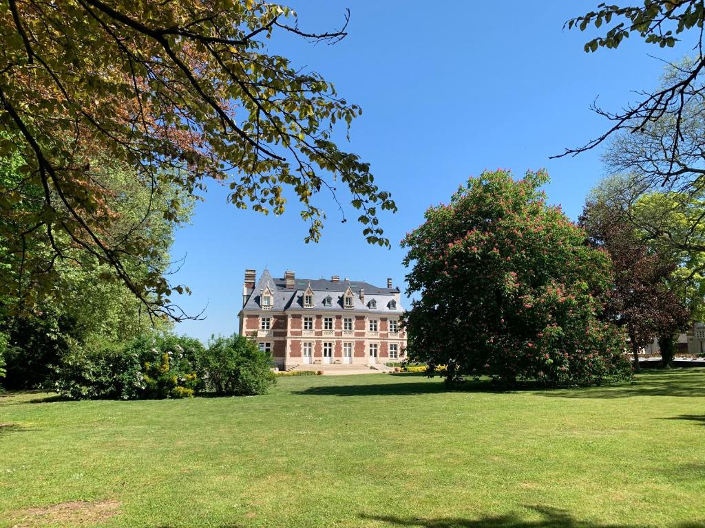 a large house in the middle of a field with trees at Château du Mont de Guny in Guny