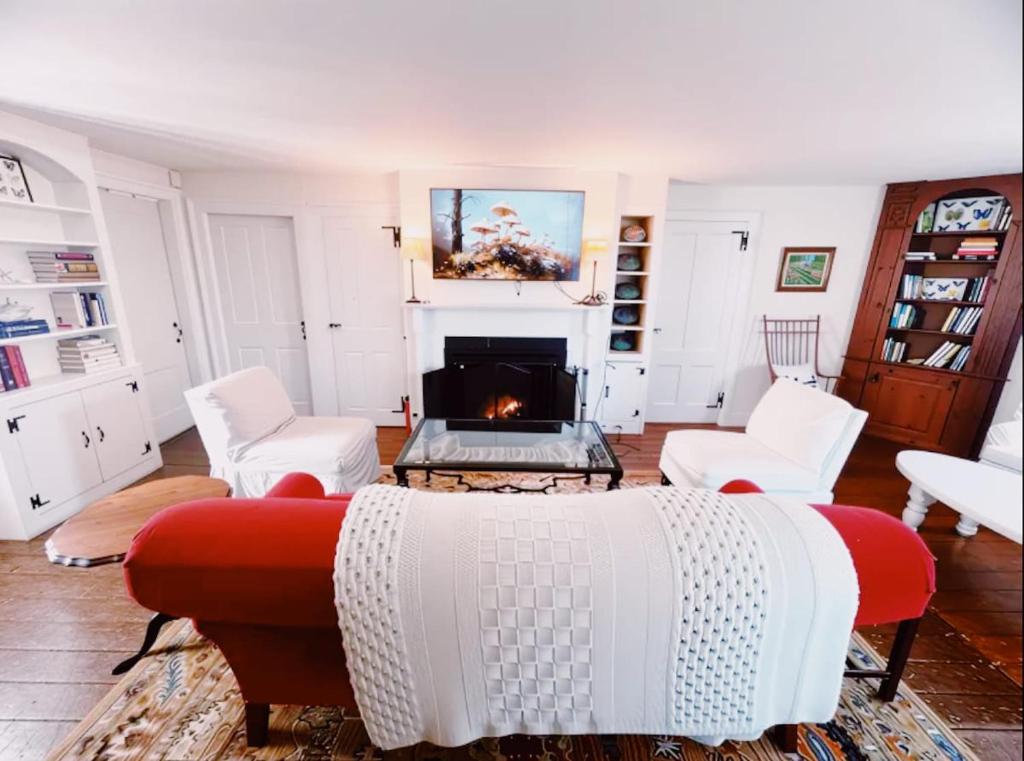 a living room with a couch and a fireplace at Capt Clarke Historic Homestead Venue in Old Saybrook