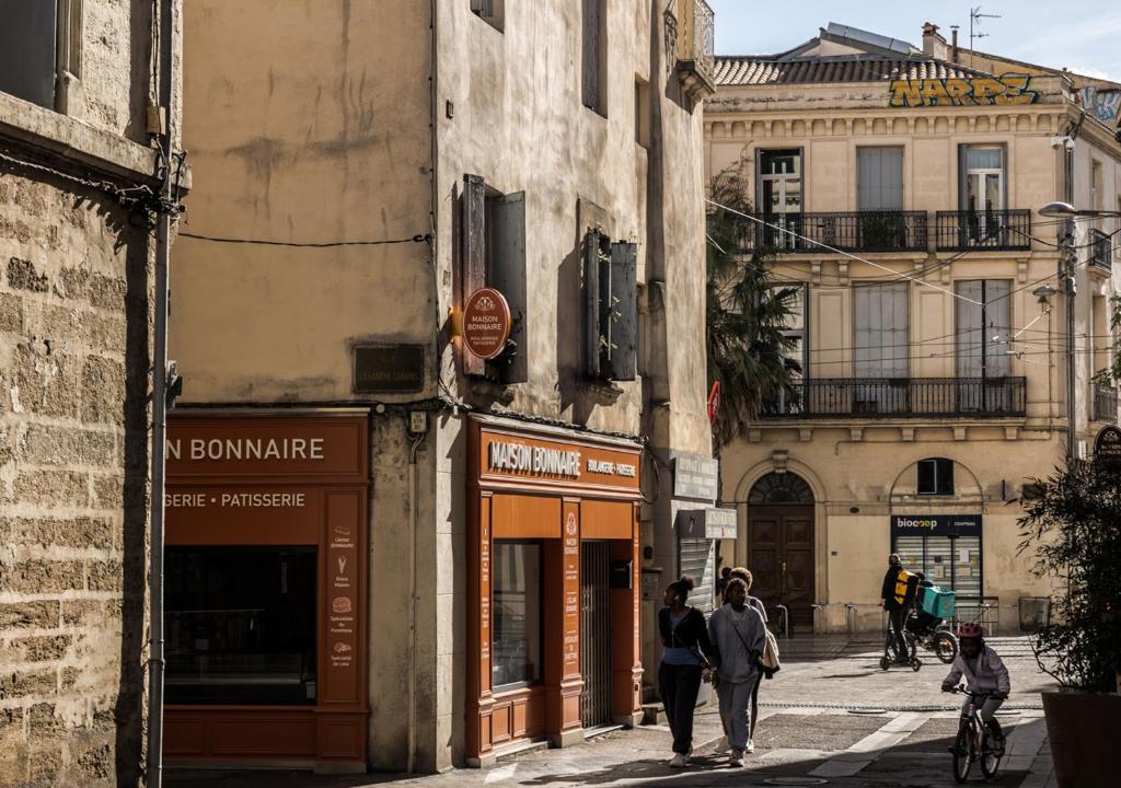 un groupe de personnes marchant dans une rue dans l'établissement Le Nid de l'Ecusson, à Montpellier