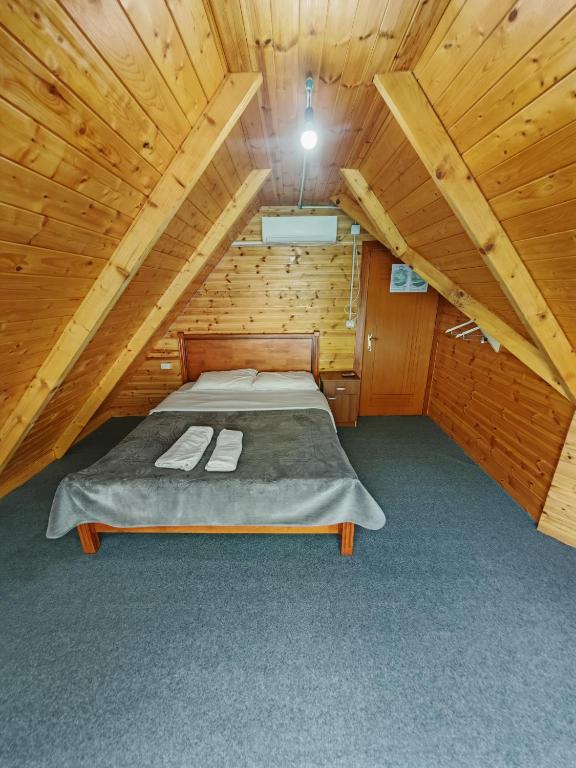 a room with a bed in a wooden cabin at Riverside Komani Lake in Koman