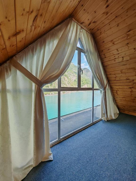 a room with a window with a view of the water at Riverside Komani Lake in Koman