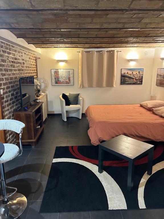 a hotel room with a bed and a chair at Studio 29 m2 proche La Défense et Arena in Nanterre