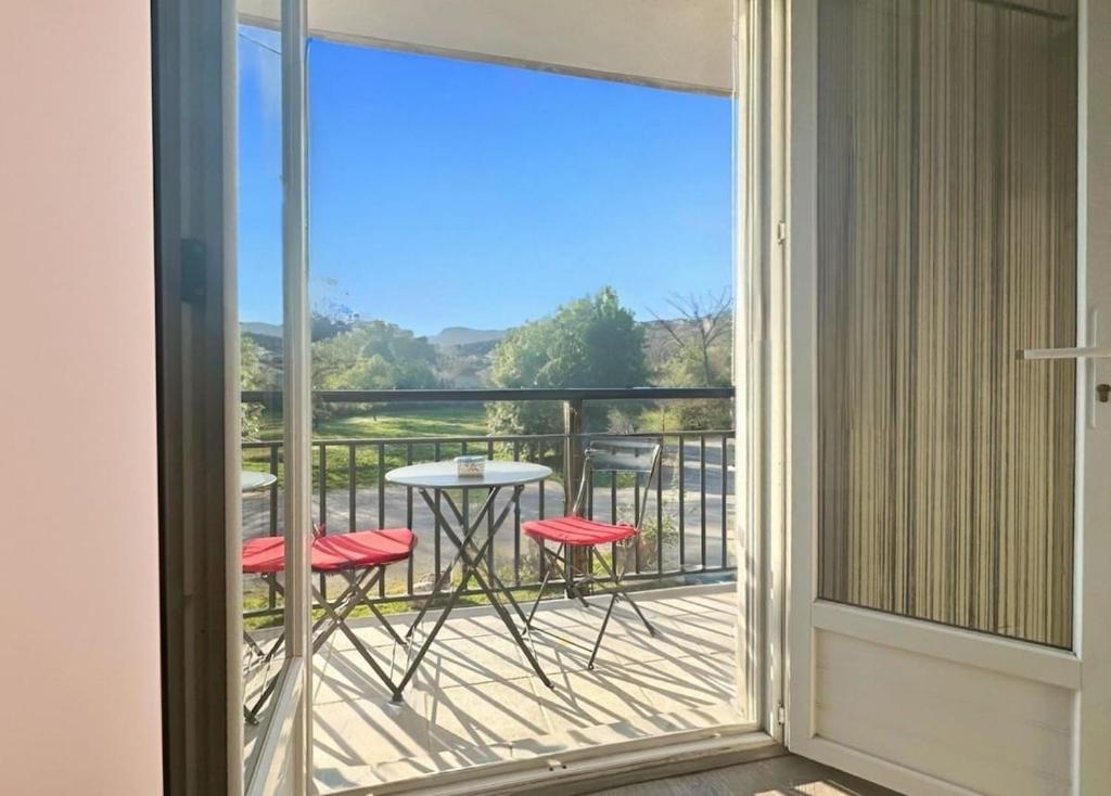 un balcon avec une table et des chaises sur une terrasse dans l'établissement Le Petit Gaudois, à La Gaude