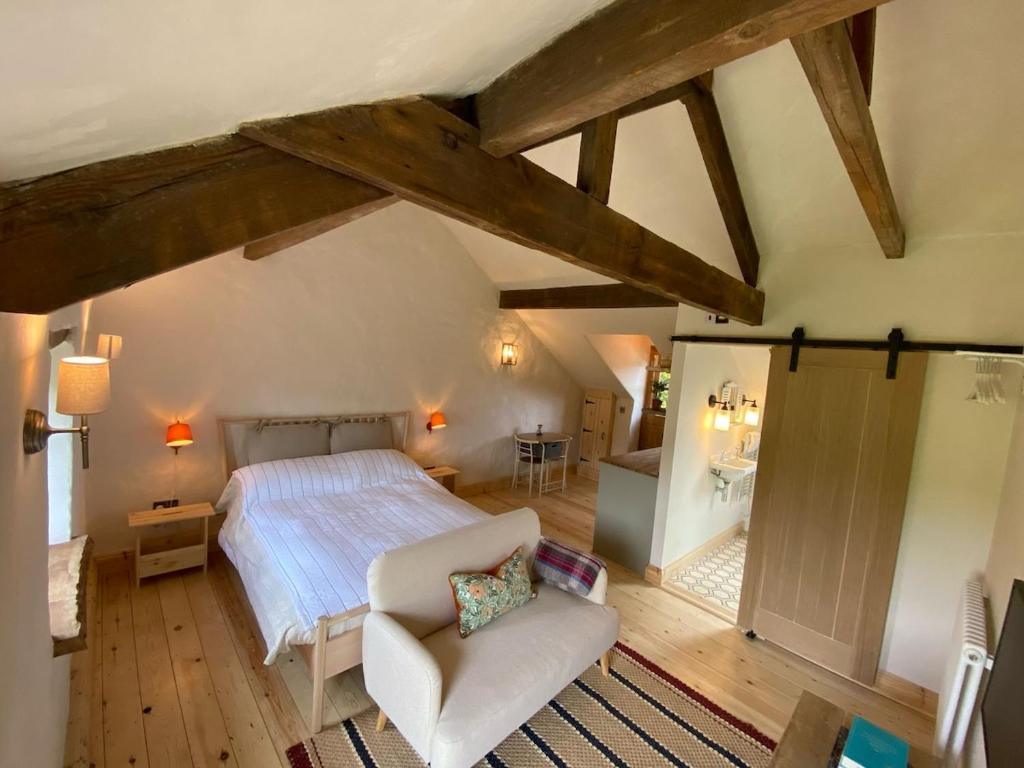 a bedroom with a bed and a chair in a room at The Stable in Usk