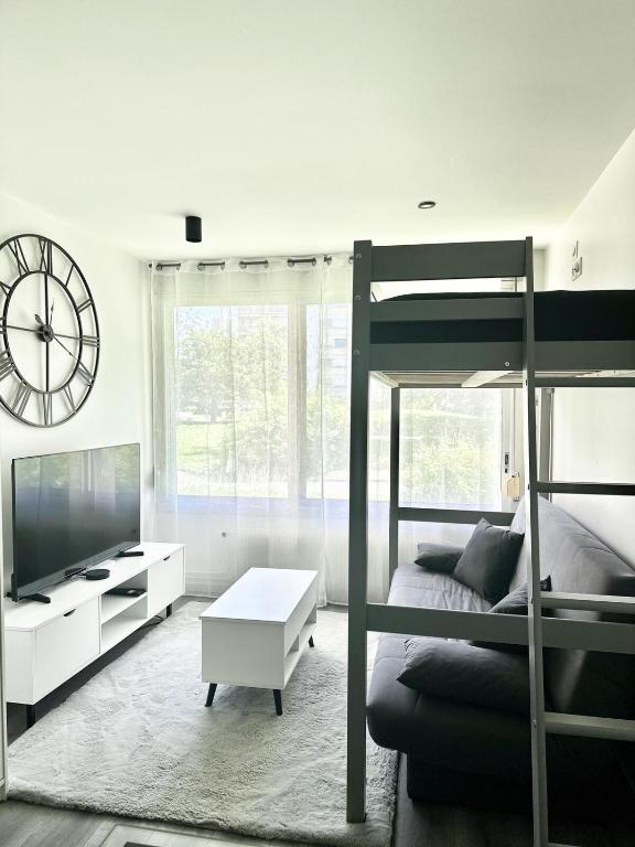 une chambre avec un lit superposé et une grande horloge dans l'établissement Studio Lyon 8 proche hôpitaux, à Lyon