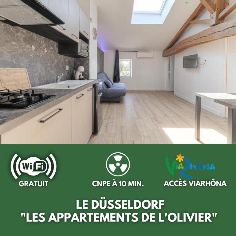 une cuisine avec des armoires blanches et une table dans une pièce dans l'établissement Le Düsseldorf - Les appartements de l'olivier, à Loyettes