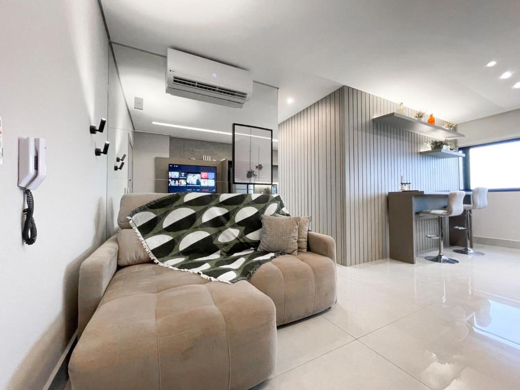 a living room with a couch and a table at Modernidade e Luxo no 30º Andar in Campo Grande