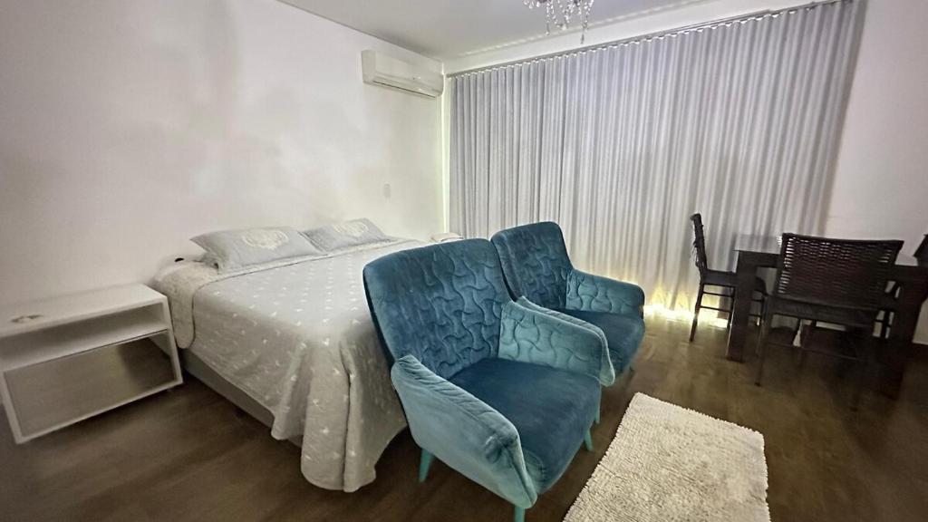 a bedroom with a bed and a chair in it at suíte completa, hidromassagem e ar condicionado in Americana