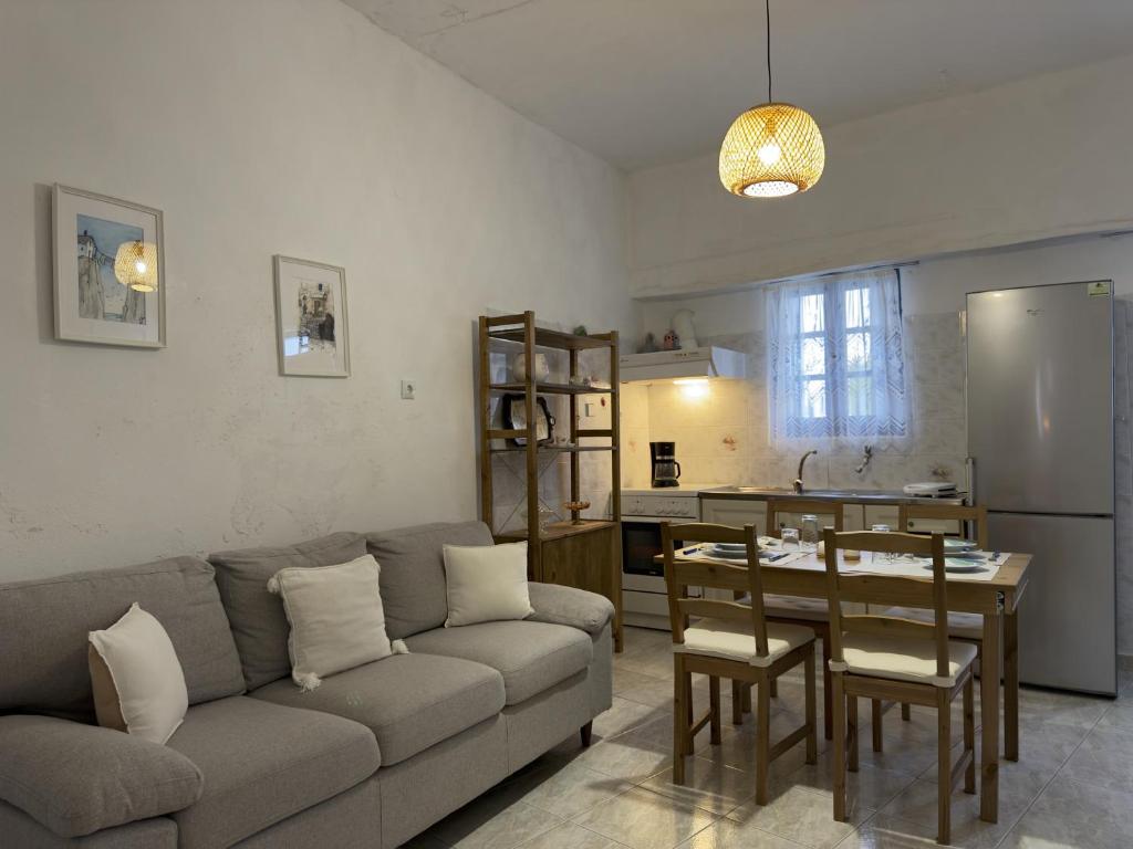 a living room with a couch and a table and a kitchen at yiayia's Place in Chora Folegandros