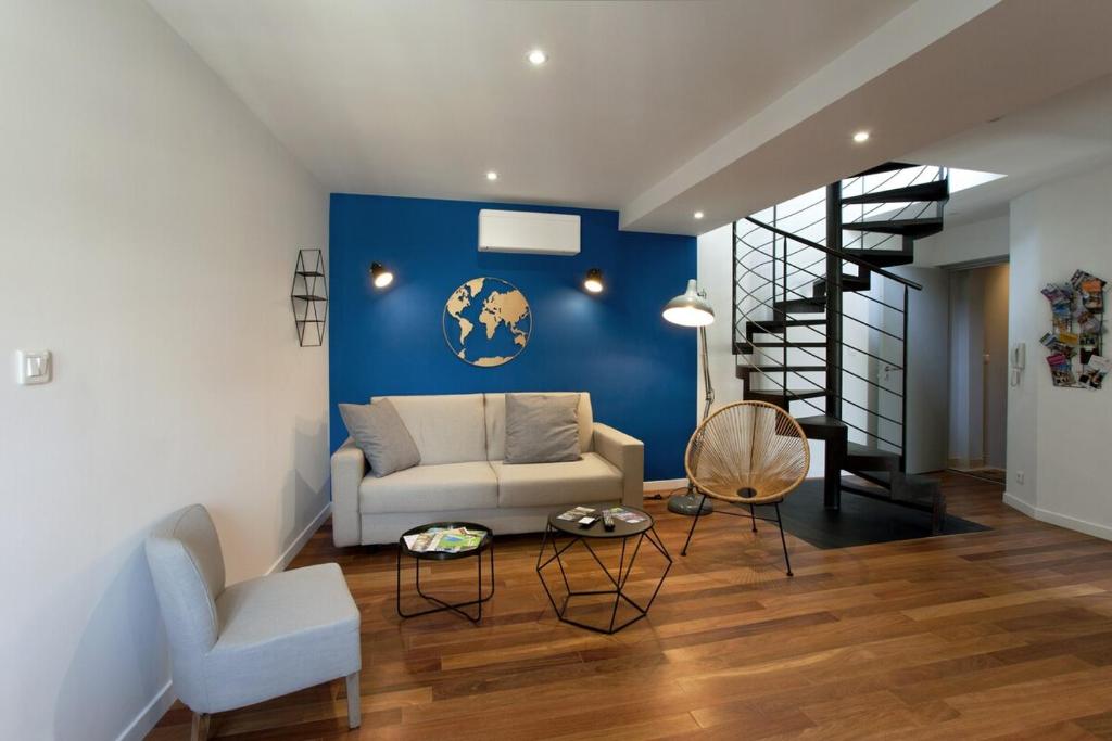 - un salon avec un canapé blanc et un mur bleu dans l'établissement Appartement L'Armande, à Arles
