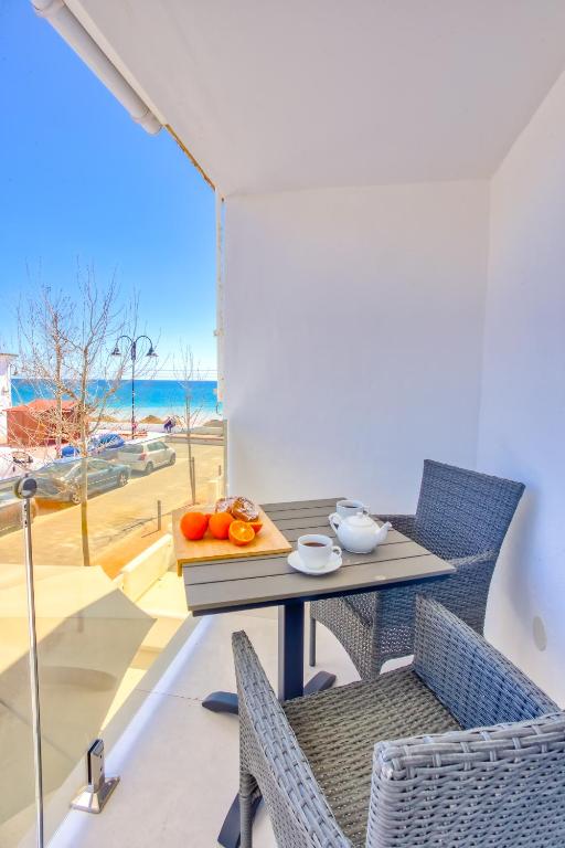 a table and chairs with a view of the ocean at Fishermans Lodge in La Cala de Mijas