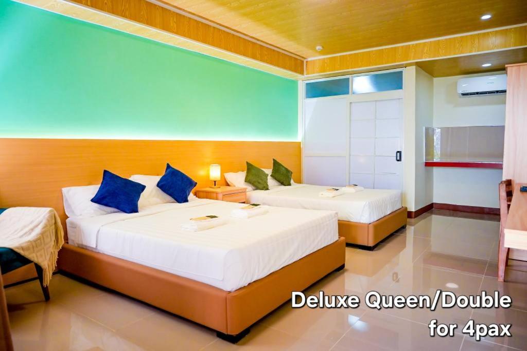 a bedroom with two beds with blue pillows at Nine Rise Travellers Inn in Plaridel