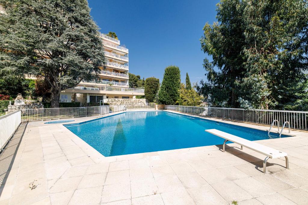 a swimming pool with a bench next to a building at GAIRAUT - 5 rooms - Terrass in Nice