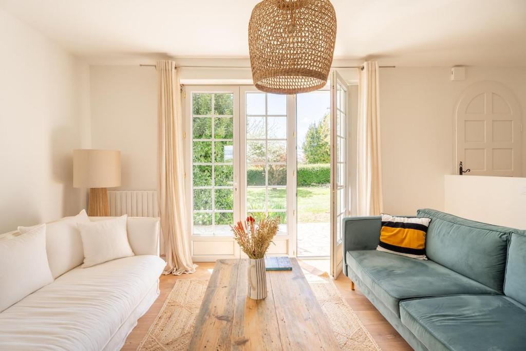 un salon avec un canapé et une grande fenêtre dans l'établissement Bois bas cottage - Baden bord de mer proche Vannes, à Baden