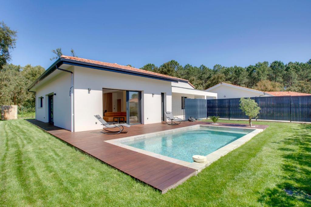 une maison avec une piscine dans une cour dans l'établissement Luxueuse villa à deux pas des plages de Capbreton, à Labenne