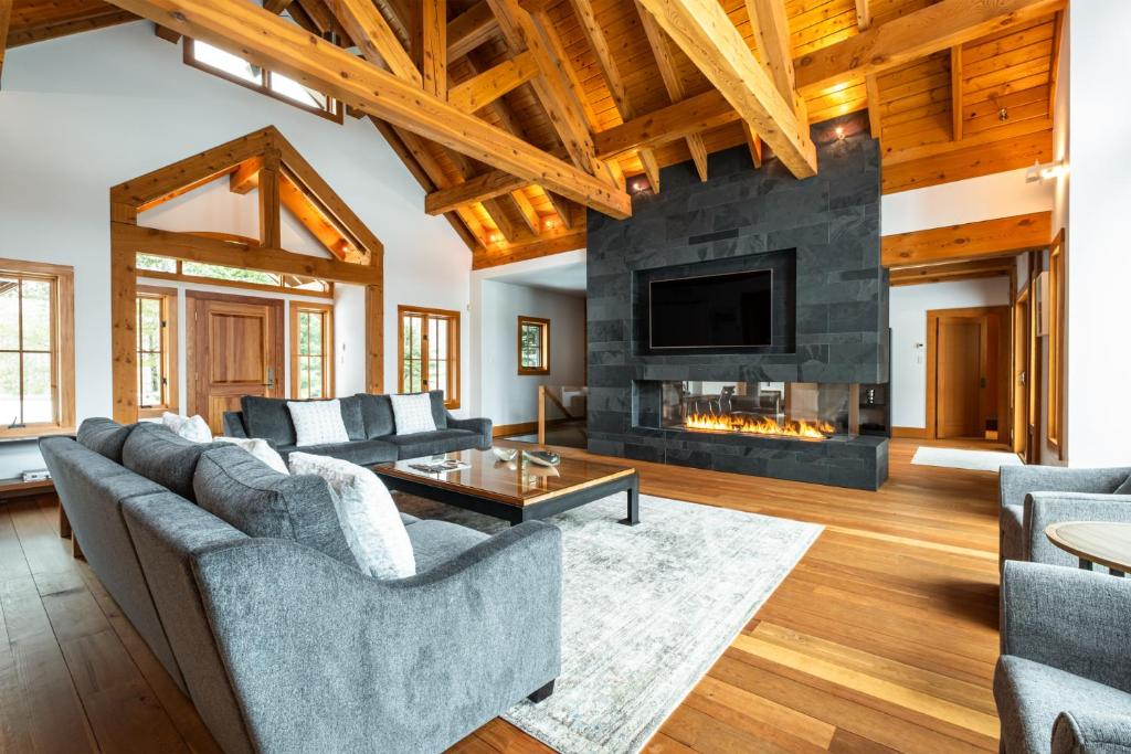 ein Wohnzimmer mit Sofas und Kamin in der Unterkunft Grand Foret Villa Luxurious Chalet with Hot Tub and Outdoor Firepit in Mont-Tremblant