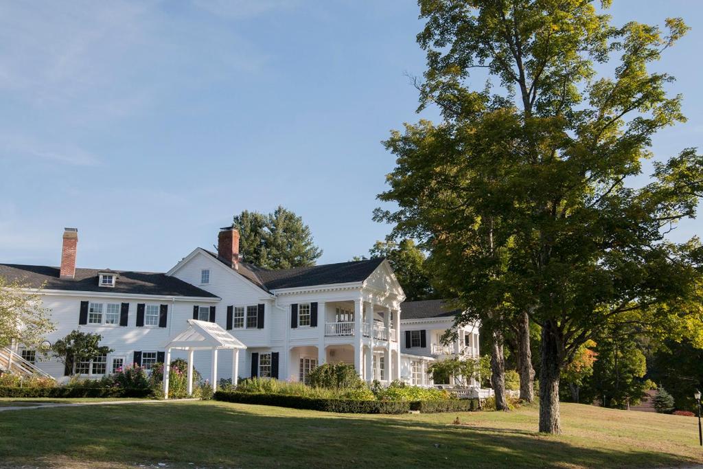 une grande maison blanche avec un arbre dans la cour dans l'établissement The White House Inn, à Wilmington