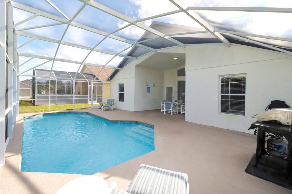 a swimming pool with a glass roof over a house at Quiet Getaway Nr Golf & Posner Park with Pool in Davenport