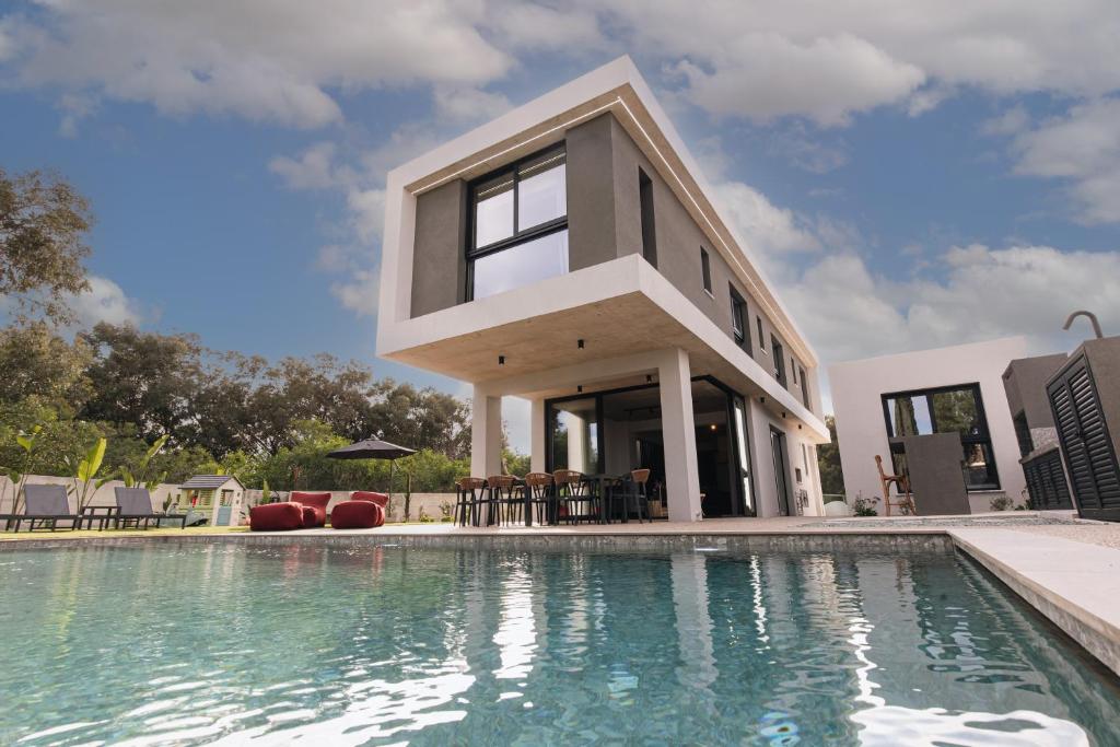 une maison avec une piscine devant une maison dans l'établissement Black Diamond Villas Protaras, à Protaras