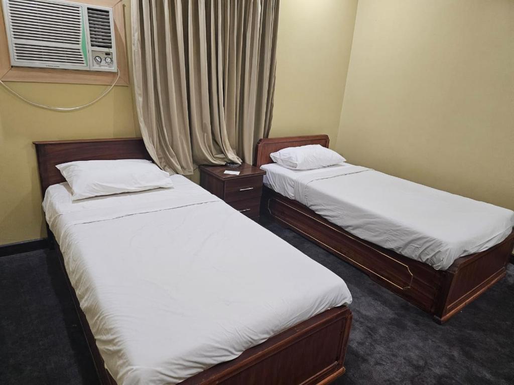 Bonais Hotel في الهفوف: سريرين توأم في غرفة مع نافذة