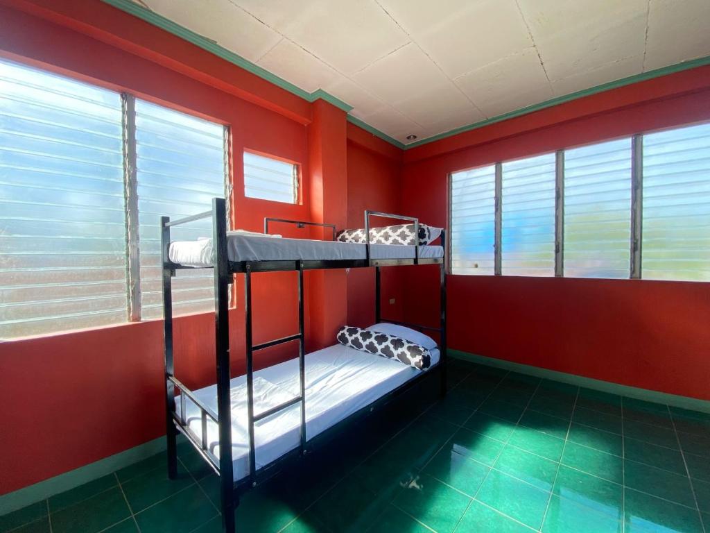 Lapu Lapu CityHostel Home in Lapu-Lapu City的红色墙壁的客房内设有两张双层床。