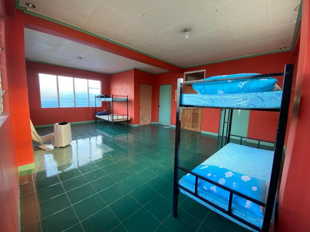 Lapu Lapu CityHostel Home in Lapu-Lapu City的红色墙壁的客房内设有两张双层床。