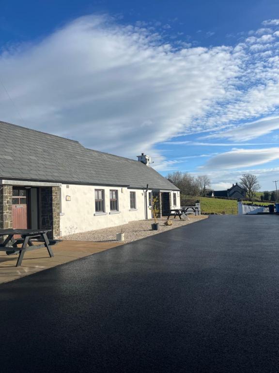 a building with a picnic table in front of it at Tavnaghoney Cottages in Cushendall