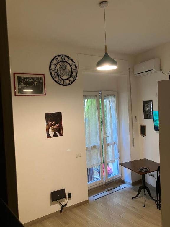 une chambre avec une horloge sur le mur et une table dans l'établissement The Green House, à Rome