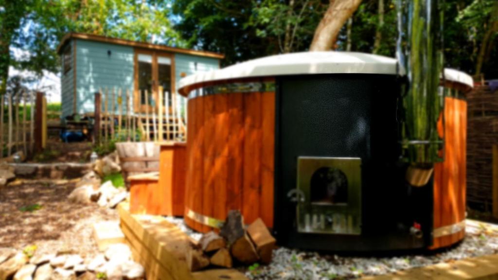 a garbage can sitting in a yard next to a house at Dowr-Gwel Shepherds Hut in Saint Cleer