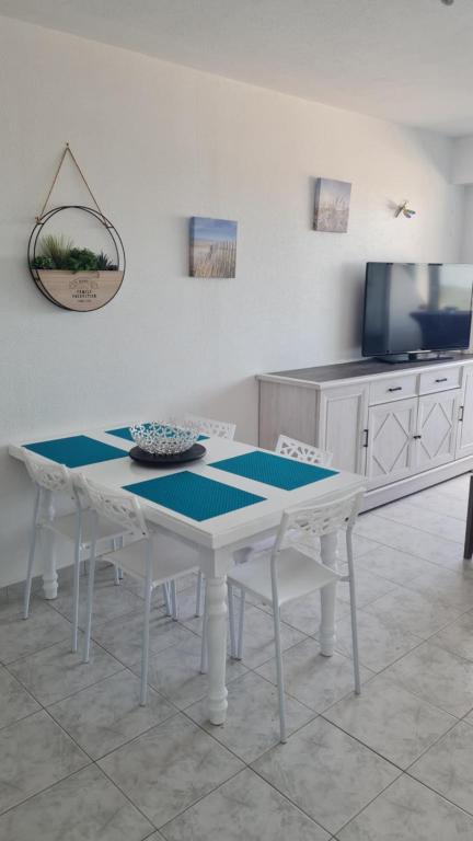 un tavolo bianco e sedie in cucina di CHARMANT T2 Avec LOGGIA VUE MER a Saint-Hilaire-de-Riez