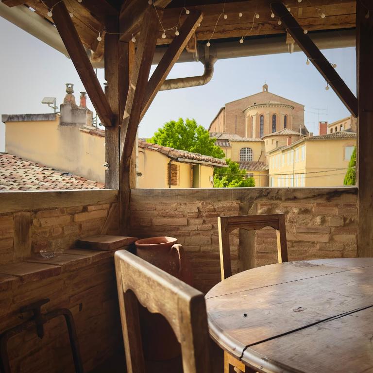 - une table et des chaises dans une chambre avec vue dans l'établissement La Bohème Saint Michel by Art&Suites, à Gaillac