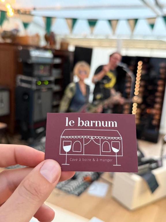 une personne tenant une carte avec une image de verres à vin dans l'établissement Lou d'Ange - Maison de campagne, à Achères