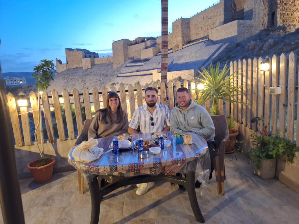 um grupo de pessoas sentadas numa mesa num pátio em Bubble castle house em Kerak