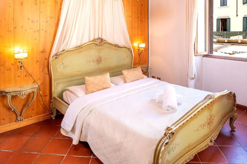 a bedroom with a large white bed with a canopy at Ca'Dinora - Venetia apartment - in Bardolino