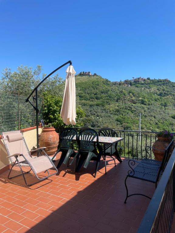 a patio with a table and an umbrella and chairs at Casa Natalina in Montecatini Terme