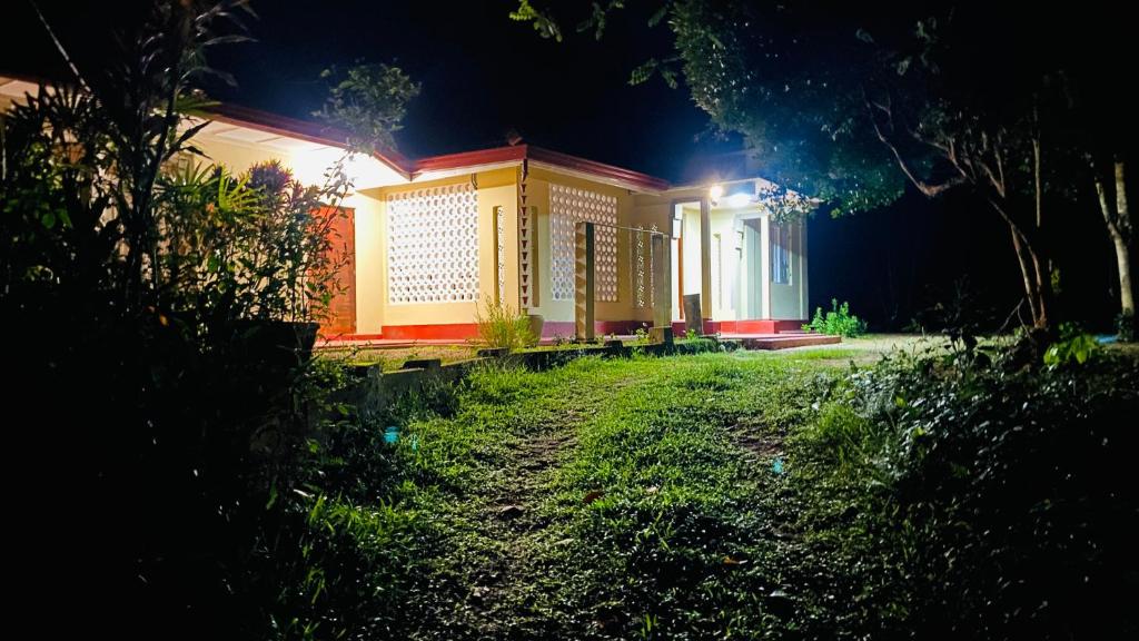 a house with lights on in a yard at night at The Old Manor - Weligama in Weligama