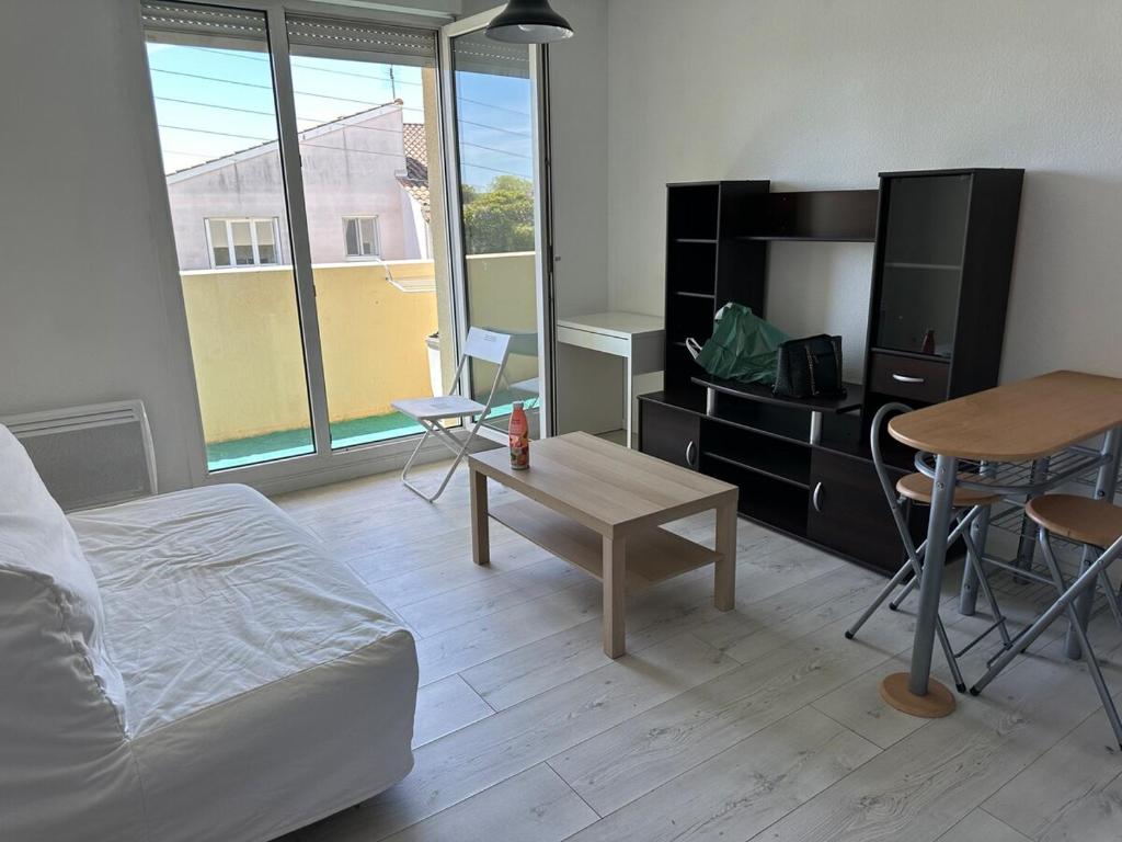 - un salon avec un lit, une table et une télévision dans l'établissement Studio avec balcon sur Talence, à Talence