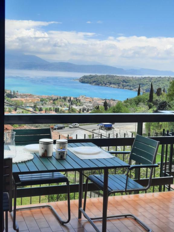 a table and chairs on a balcony with a view of a lake at Lake Breeze Salò in Salò