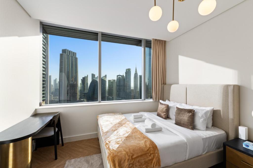 Luxury Apt DIFC, XL Layout, Pool, Gym, Skyline View في دبي: غرفة نوم بسرير ومكتب ونافذة