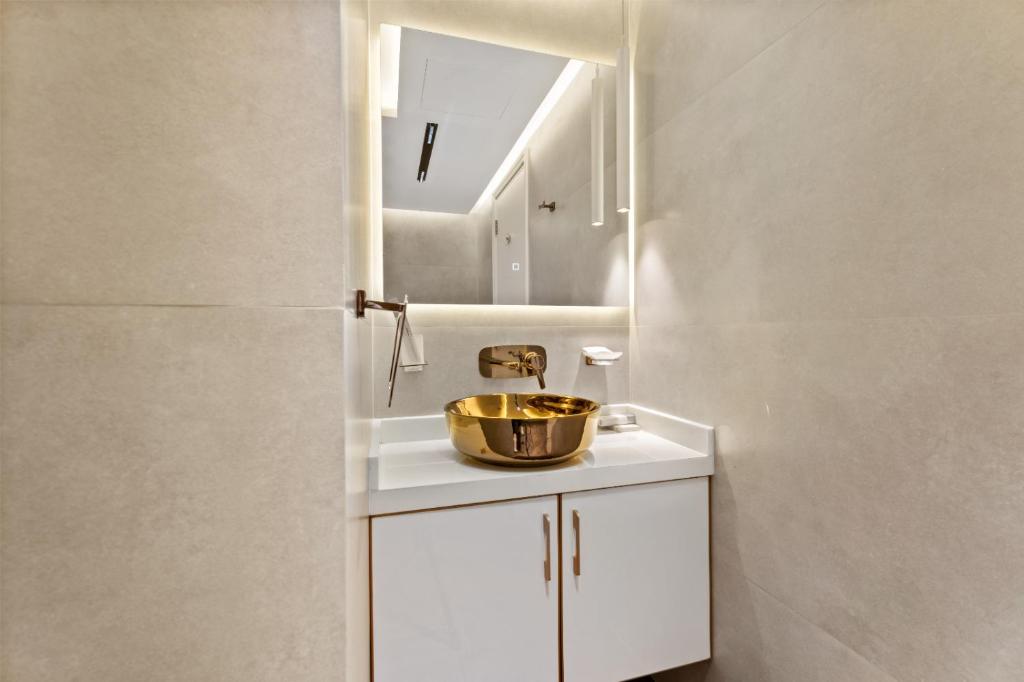 Luxury Apt DIFC, XL Layout, Pool, Gym, Skyline View في دبي: حمام مع حوض ومرآة