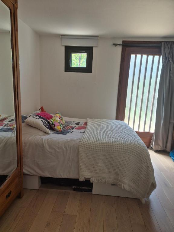 une chambre avec un lit, un miroir et une fenêtre dans l'établissement Grande maison près du centre, à La Celle-sous-Gouzon