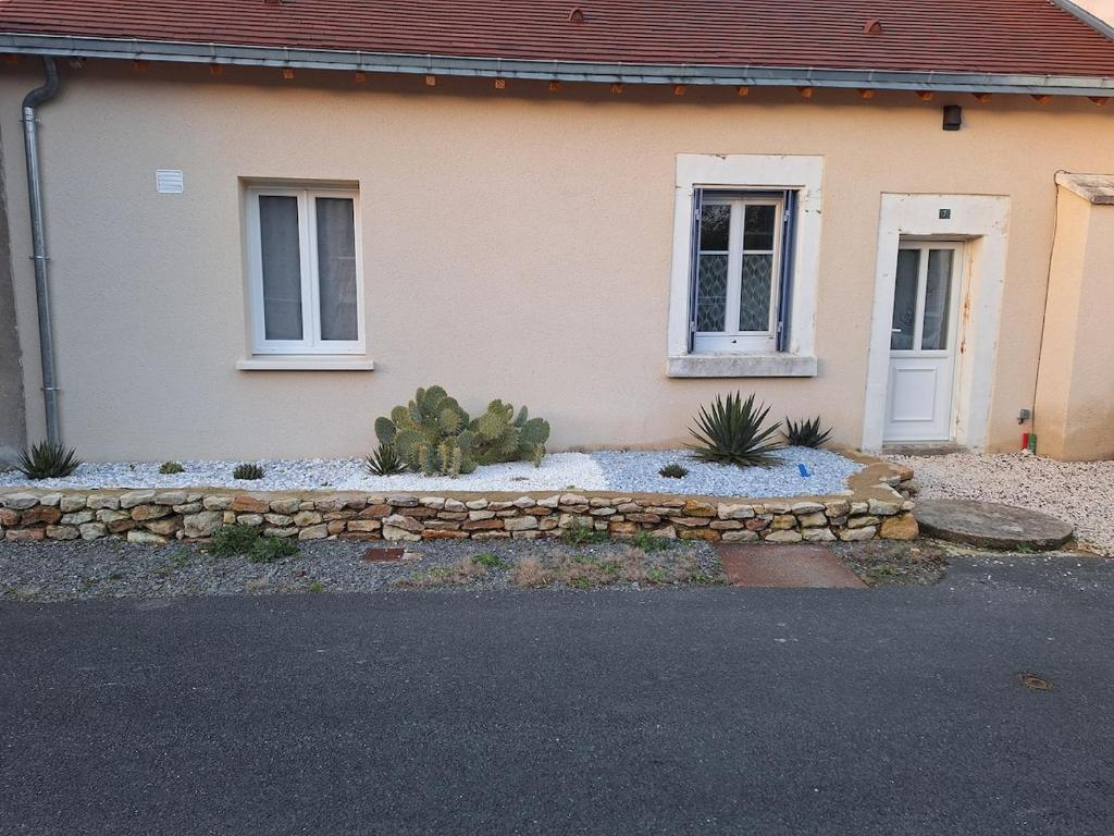 una casa con un muro di pietra di fronte di Agréable maison au cœur d'un petit village a Saint-Genou
